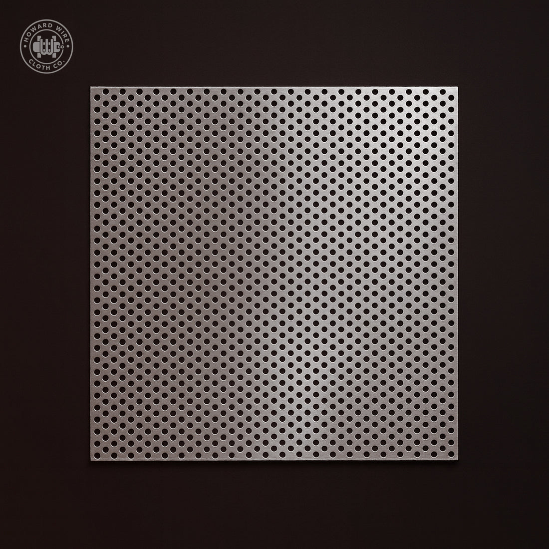 Studio product photograph of Type 304 stainless steel perforated coil, .094 inch round holes on .156 inch staggered centres, 18 gauge, on a dark graphite background.