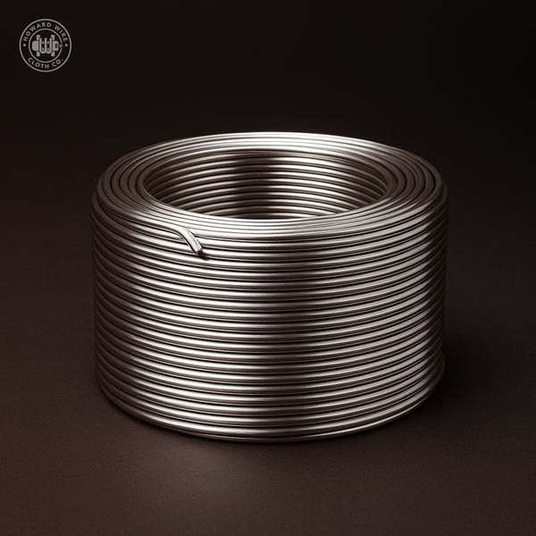 Studio product photograph of a coil of .120 inch diameter Type 304 stainless steel wire, on a dark graphite background.